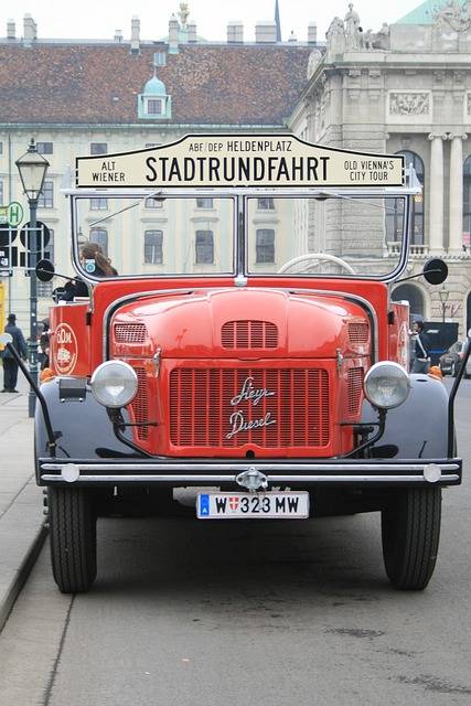 Wien bei einer kostenlosen Stadtrundfahrt mit der Straßenbahn erleben. Das geht mit einem Ticket für den ÖPNV. Im Bild einer roter Stadtrundfahrten-Oldtimer.